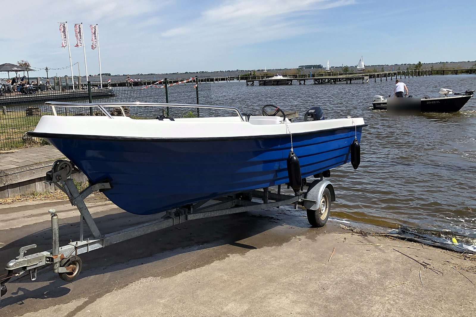 Blauwe sloep met witte binnenkant bij het water